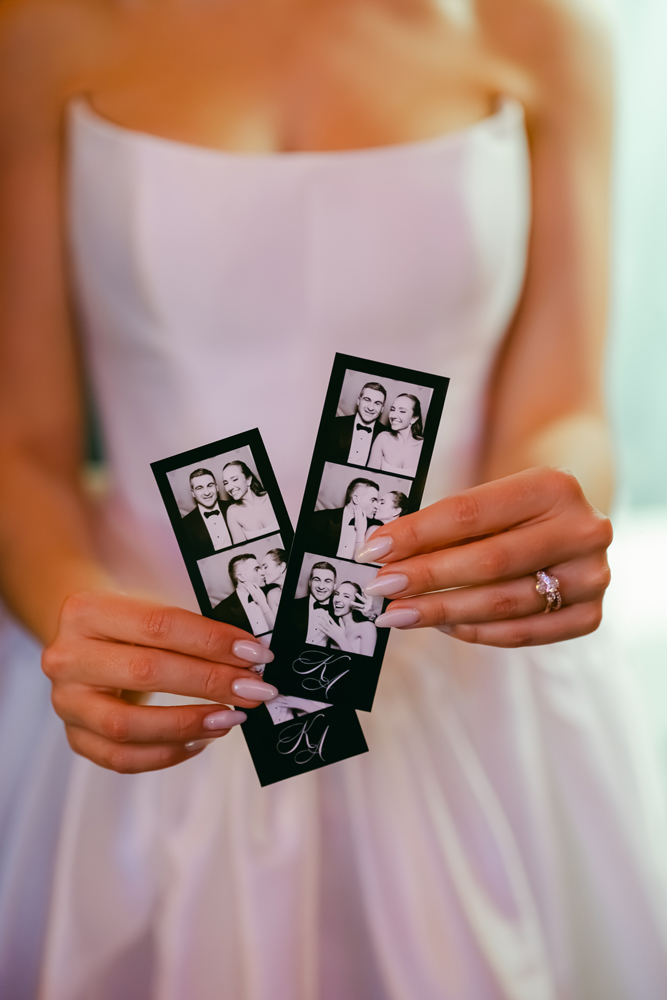 Bride holding her vintage black & white photos from her wedding enclosed photo booth
